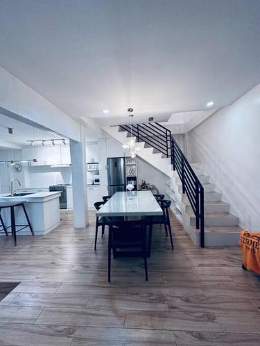 a dining room with a table and a staircase at White Villa in General Santos