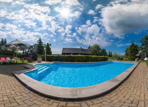 a swimming pool in a yard with a blue sky at Hotel Alpenhof in Markneukirchen