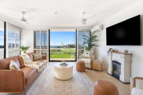 a living room with a couch and a fireplace at Beach Front Oasis with Private Courtyard in Gold Coast