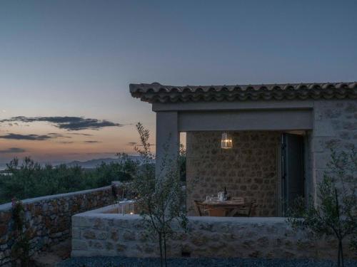 a stone building with a table in front of it at Poliana Estate Villas in Riglia