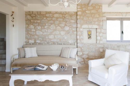 a room with a bed and a couch and a table at Poliana Estate Villas in Riglia