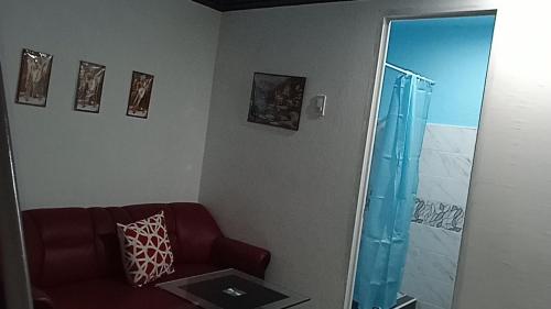 a living room with a red chair and a mirror at Sarah's Garden BnB & BnB Spa Family room with livingroom in Clarin