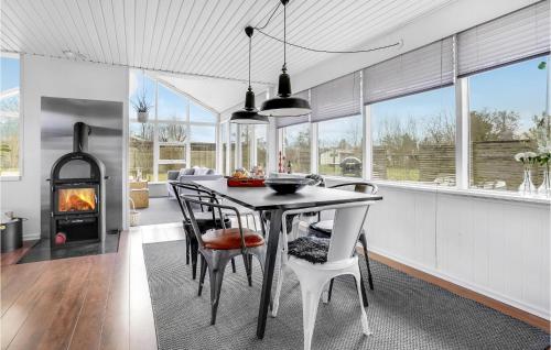 a dining room with a table and chairs and a fireplace at Beautiful Home In Otterup With Kitchen in Otterup