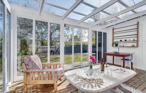 a conservatory with a table and chairs and a glass ceiling at Holiday Home Sneppevej Rødby Denm in Kramnitse