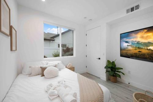 1 dormitorio blanco con 1 cama blanca grande y TV en Prime Location 3BD 3BA Luxury Living in LA, en Los Ángeles