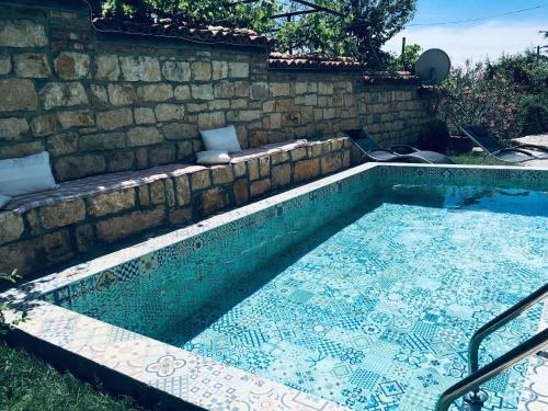 - une piscine avec un mur en pierre dans l'établissement Ferienhaus auf zwei Etagen, mit Garten und überdachtem Grillplatz, à Galata