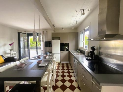 - une cuisine avec une grande table et des chaises dans l'établissement Maison de charme rénovée près du port ostréicole, idéale pour vacances à pied ou à vélo - FR-1-420-147, à La Teste-de-Buch