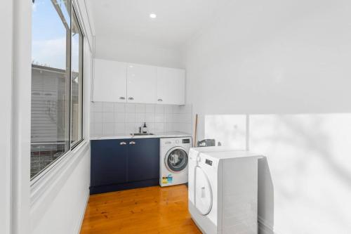 a kitchen with a washing machine and a window at Wander Lake Wendouree near Ballarat Central in Ballarat