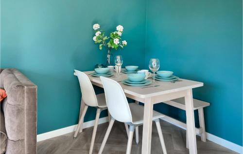 a dining room table with chairs and a blue wall at Gorgeous Home In Heinkenszand With Wifi in Heinkensand