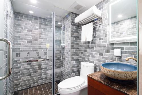 a bathroom with a sink and a toilet and a shower at Nost algia Hotel Beijing Tiananmen Square & Qianmen Subway St ation 时光漫步酒店 北京天安门广场前门地铁站店 Free laundry service in Beijing