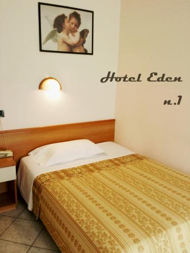 a hotel room with a bed and a sign on the wall at Hotel Eden in Milan