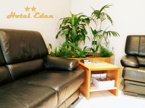 a leather couch in a room with plants at Hotel Eden in Milan