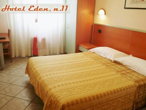 a bedroom with a large bed with a wooden headboard at Hotel Eden in Milan