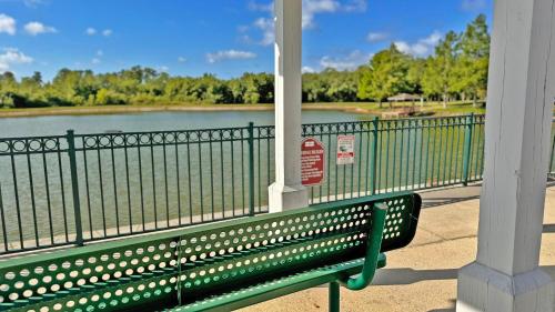 a green bench sitting next to a body of water at Villas at Seven Dwarfs Resort - Near to Disney in Kissimmee