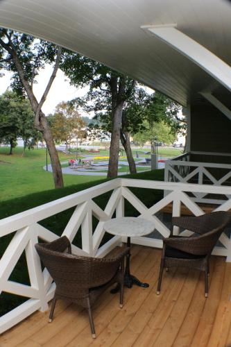 a porch with two chairs and a table on a deck at Vila Klasika in Birštonas