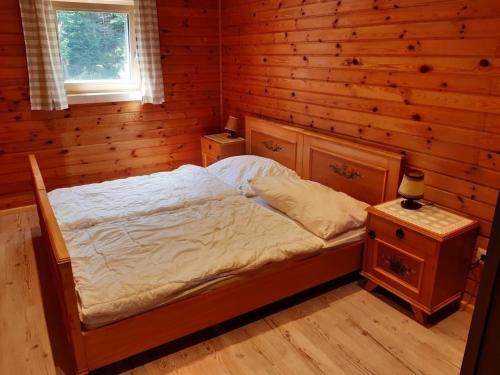 a bedroom with a bed and a wooden wall at Ferienhaus Teichhaus in Grades in Grades