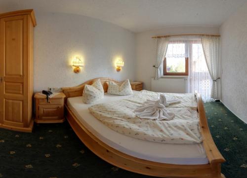 a bedroom with a large bed with a wooden frame at Hotel Alpenhof in Markneukirchen