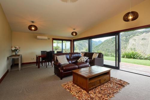 a living room with a couch and a table at Glencree Luxury Chalets in Kaikoura