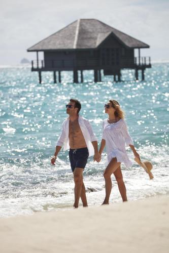a man and a woman walking on the beach at Mandarin Oriental, Canouan in Canouan