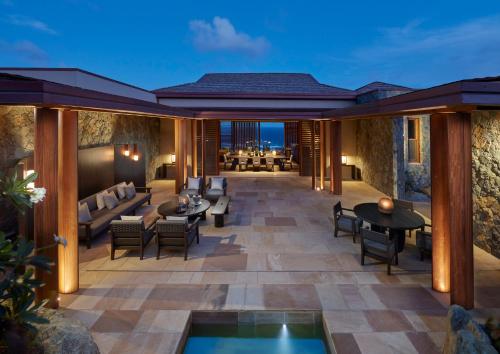 a patio with couches and tables and chairs at Mandarin Oriental, Canouan in Canouan
