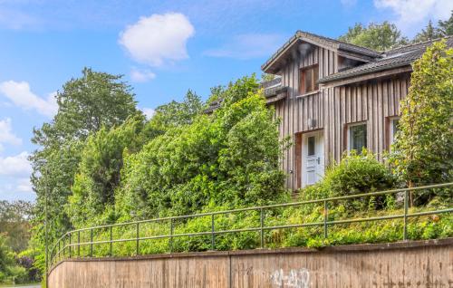 a house on a retaining wall with a fence at Waldblick in Glücksburg