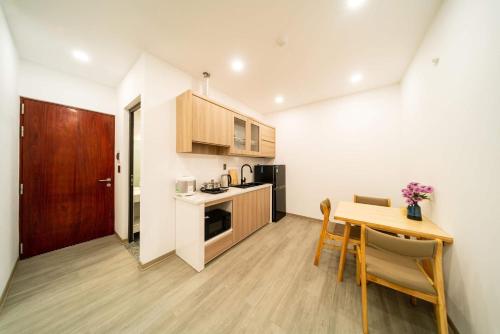 a small kitchen with a table and a dining room at 2CE APARTMENT & HOTEL in Hai Phong