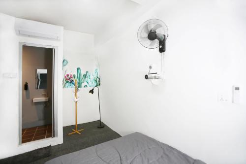 a white room with a bed and a fan at HangoutSpacez Queensbay at Bayan Lepas Penang in Bayan Lepas