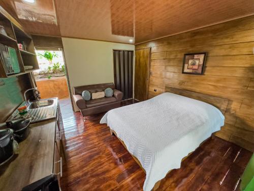a bedroom with a bed and a couch at Cabañas Vistas de Altura por Hermanos Solano in San Francisco