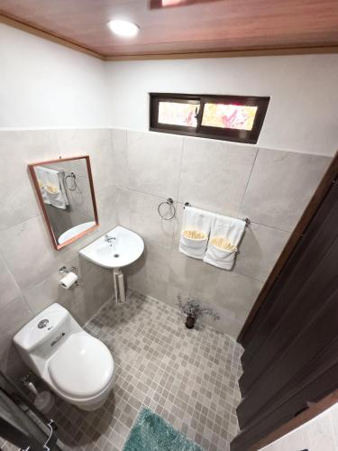 a bathroom with a white toilet and a sink at Cabañas Vistas de Altura por Hermanos Solano in San Francisco