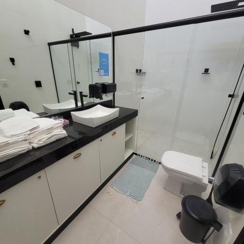 a bathroom with a toilet and a sink and a shower at Happy Buritis, eventos e hospedagem in Primavera do Leste