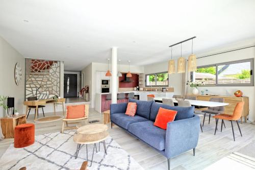 un salon et une cuisine avec un canapé bleu et des coussins orange dans l'établissement Family house with private pool, à La Baule