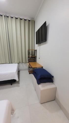 a room with two beds and a flat screen tv at Happy Buritis, eventos e hospedagem in Primavera do Leste