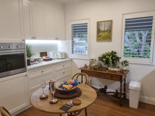 a kitchen with a wooden table and a table sidx sidx sidx at Peppercorn Cottage at Treetops Red Hill in Red Hill