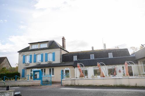 une maison avec des volets et des fenêtres bleus et une rue dans l'établissement Hotel Restaurant des 4 Ecluses, à Gaillon