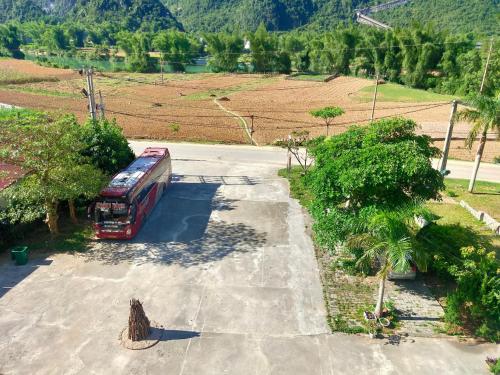 a red bus is parked in a parking lot at Khách sạn So Oanh gần thác Bản giốc in Cao Bằng
