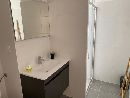 une salle de bain blanche avec un lavabo et un miroir dans l'établissement Duplex T4 Climatisé avec Terrasse, Parking et Plage à Proximité - Port Leucate, 8 Pers. - FR-1-798-1, à Leucate