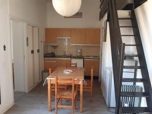 une cuisine avec une table et des chaises en bois ainsi qu'un escalier dans l'établissement Moderne T2 Mezzanine - 6 Pers. Près Plage et Port, Parking Privé, 36m², Terrasse - Port Leucate - FR-1-798-7, à Leucate