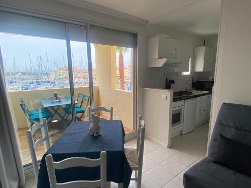 une cuisine avec une table et un chat assis sur elle dans l'établissement Port Leucate: T2 Alcove Climatisé, 6 Pers, Parking, Animaux bienvenus - FR-1-798-11, à Leucate
