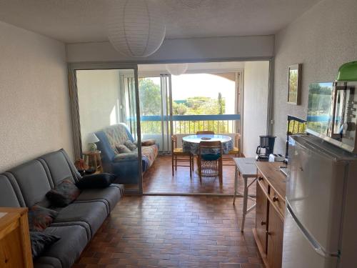 un salon avec un canapé et une table dans l'établissement Studio Loggia avec Piscine, 4 Pers., Port Leucate, Parking - FR-1-798-14, à Leucate
