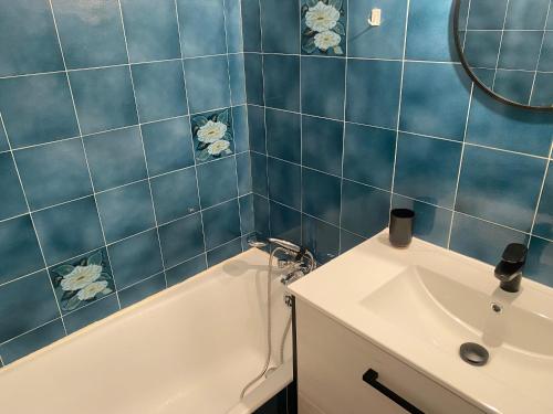 une salle de bain carrelée bleue avec un lavabo et une baignoire dans l'établissement Studio Loggia avec Piscine, 4 Pers., Port Leucate, Parking - FR-1-798-14, à Leucate