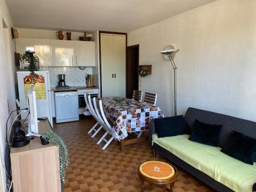 un salon avec un canapé et une table et une cuisine dans l'établissement Charmant T3 de plain pied, 4/5 pers, proche plage, parking privé, animaux OK - FR-1-798-17, à Leucate