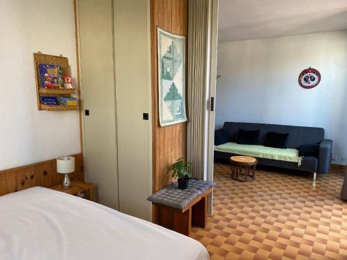 une chambre d'hôtel avec un lit et un canapé dans l'établissement Charmant T3 de plain pied, 4/5 pers, proche plage, parking privé, animaux OK - FR-1-798-17, à Leucate