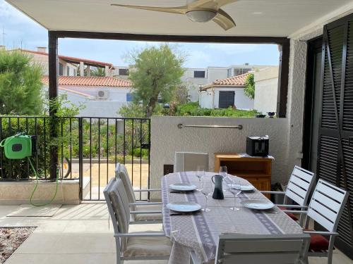d'une table à manger et de chaises sur une terrasse avec balcon. dans l'établissement Villa T3 Climatisée à Port Leucate, 6 Pers, Proche Mer avec Parking Sécurisé - FR-1-798-33, à Leucate
