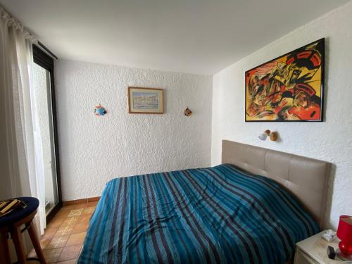 une chambre avec un lit et un tableau au mur dans l'établissement Villa T3 Climatisée à Port Leucate, 6 Pers, Proche Mer avec Parking Sécurisé - FR-1-798-33, à Leucate