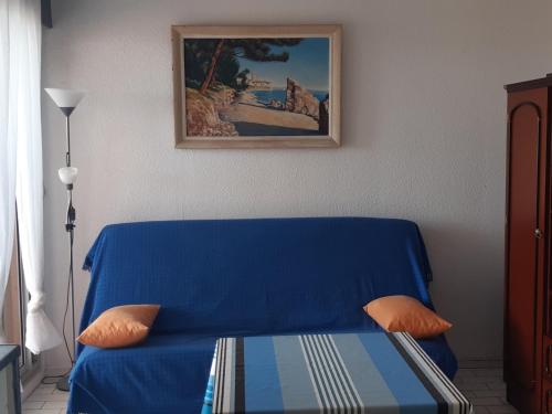 - un canapé bleu dans une pièce ornée d'une peinture murale dans l'établissement Beau Studio Cabine 4 Pers, 1er Étage, Vue Mer, Parking Port Leucate - FR-1-798-35, à Leucate