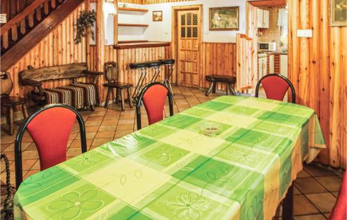a dining room with a green table and chairs at Holiday Home Barczewo Kaplityny Iv in Barczewo
