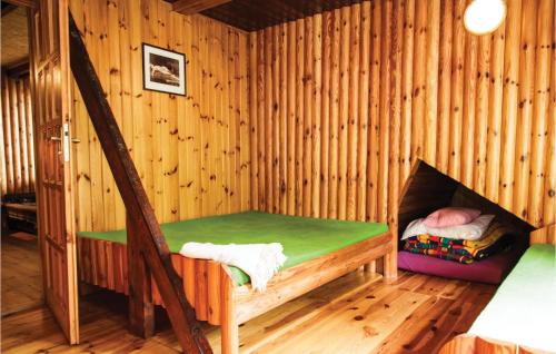 a small room with a bed in a wooden cabin at Holiday Home Barczewo Kaplityny Iv in Barczewo