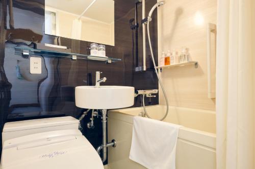 a bathroom with a white toilet and a sink at Hotel Kumamoto Terrsa in Kumamoto