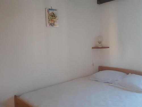 - un lit blanc dans une chambre avec une photo sur le mur dans l'établissement Villa T3 Mezzanine, 6 pers., Accès plage, Parking, Animaux admis - FR-1-798-39, à Leucate