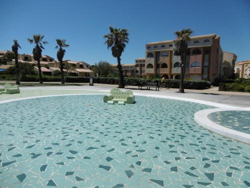 une piscine avec un banc au milieu dans l'établissement Appartement T2 Mezzanine Climatisé, 6 Pers, Proche Mer, Parking Privé, Leucate - FR-1-798-10, à Leucate